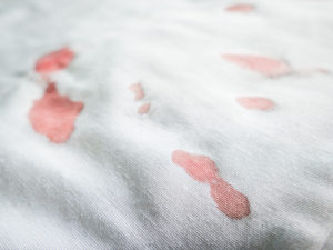 Linen with faded bloodstains on them needing to be laundered