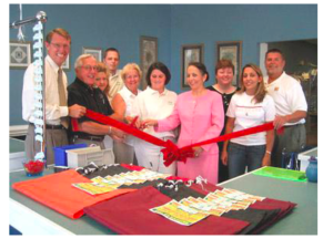 Village Cleaners family and staff cutting the ceremonial opening ribbon.